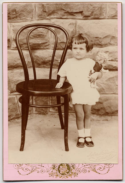 Ritratto di bambina con bambola in braccio